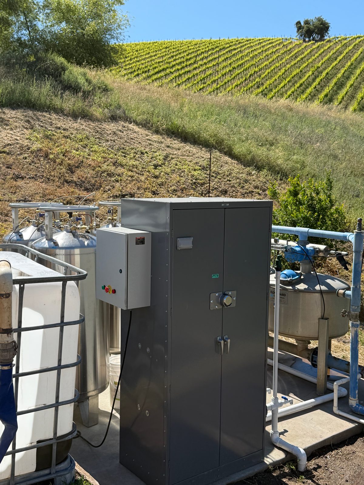 ECO2MIX carbonic acid system at a vineyard pump station, vineyard blocks on the hillside behind